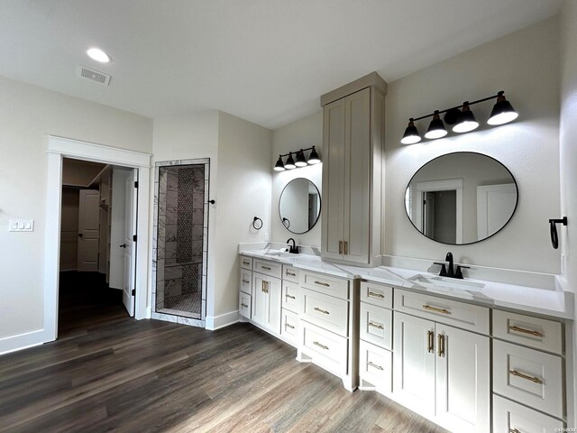 full bath featuring wood finished floors, a sink, and visible vents