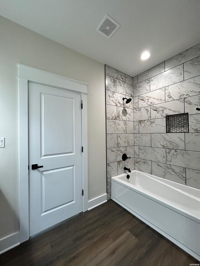 bathroom with recessed lighting, wood finished floors, visible vents, baseboards, and shower / bathing tub combination