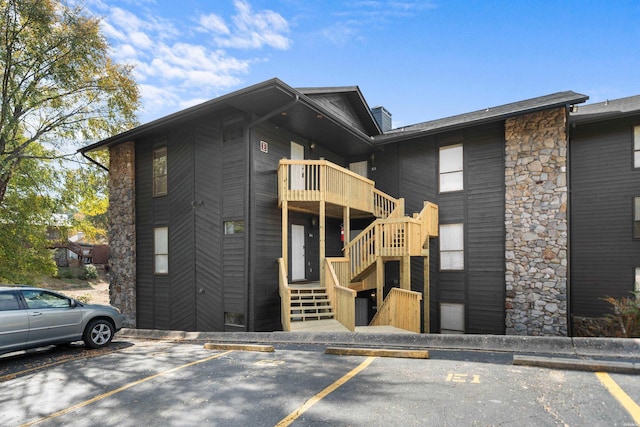 203 Stearns Pt Unit E1, Hot Springs, AR 71913 - view of front of property with uncovered parking, stone siding, stairway, and a balcony