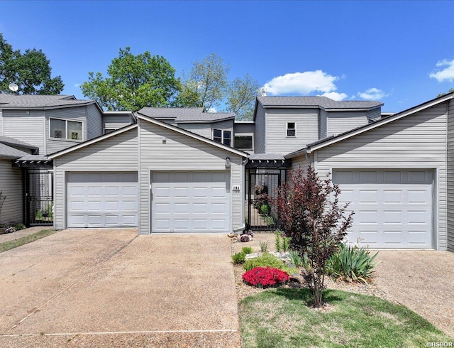 view of front of house with concrete driveway, an attached garage, and roof with shingles
