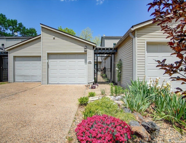view of front of home featuring an attached garage, fence, and driveway