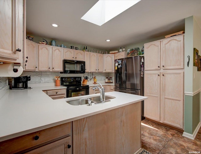 kitchen with a sink, light brown cabinets, decorative backsplash, and black appliances