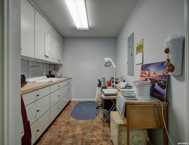 home office featuring baseboards and electric panel