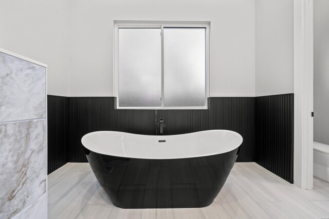106 Imperial Ct, Hot Springs, AR 71913 - bathroom with a wainscoted wall, a freestanding tub, and toilet