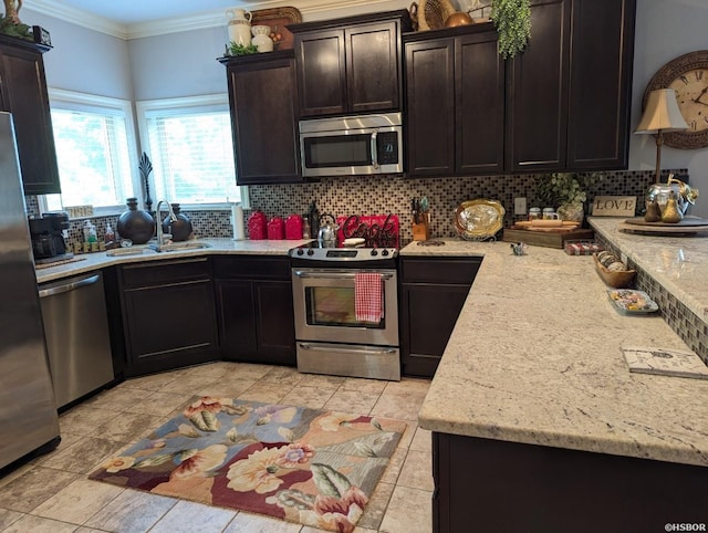 kitchen with tasteful backsplash, stainless steel appliances, dark brown cabinets, crown molding, and a sink