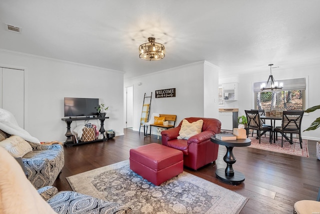 living area featuring crown molding, dark wood-style flooring, visible vents, and a notable chandelier