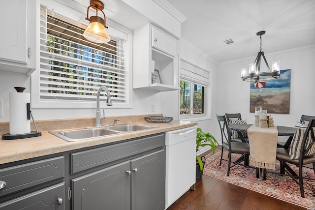 kitchen with white dishwasher, a sink, light countertops, gray cabinets, and pendant lighting