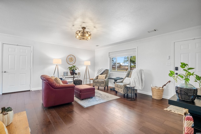 living room with a textured ceiling, dark wood-style flooring, visible vents, baseboards, and ornamental molding