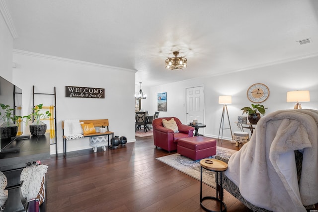 living room with baseboards, visible vents, ornamental molding, dark wood-type flooring, and an inviting chandelier