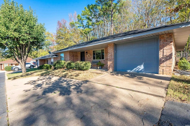view of front of house with a garage, concrete driveway, and brick siding