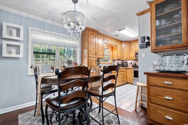 dining area featuring crown molding, dark wood-style flooring, a textured ceiling, and an inviting chandelier