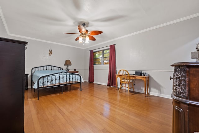 bedroom with light wood-type flooring, crown molding, and baseboards