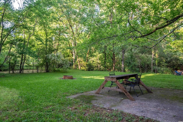 view of green lawn featuring a wooded view