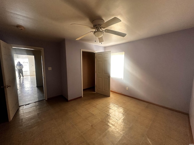 unfurnished bedroom featuring a ceiling fan and baseboards