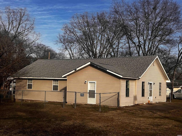 view of side of property with roof with shingles and fence