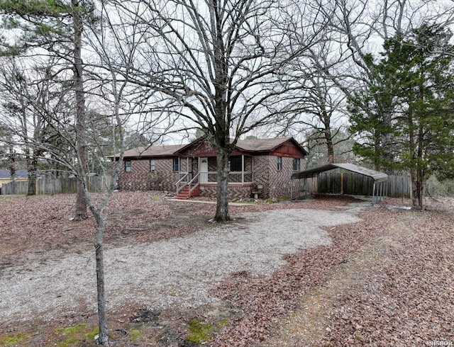 view of front of home with a detached carport, brick siding, and driveway