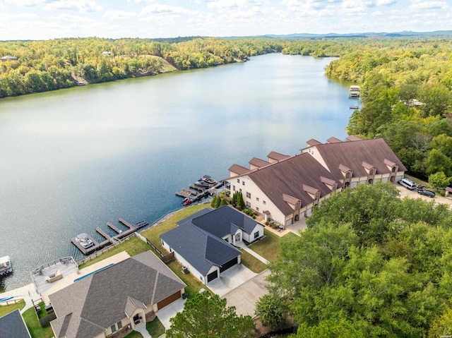 drone / aerial view featuring a wooded view and a water view