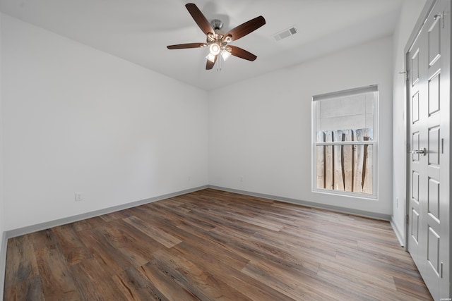 spare room with visible vents, baseboards, a ceiling fan, and wood finished floors