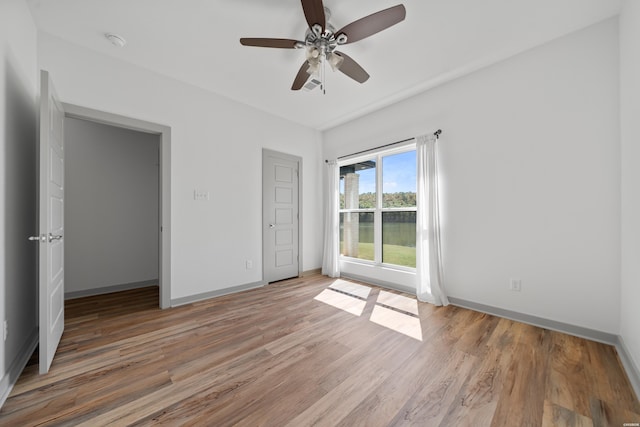 unfurnished bedroom with baseboards, light wood-style flooring, and a ceiling fan