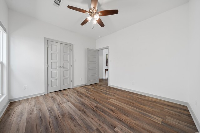 unfurnished bedroom featuring visible vents, baseboards, wood finished floors, and a ceiling fan