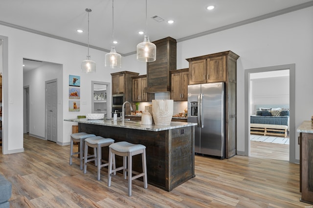 kitchen featuring visible vents, light wood-style floors, appliances with stainless steel finishes, crown molding, and decorative backsplash