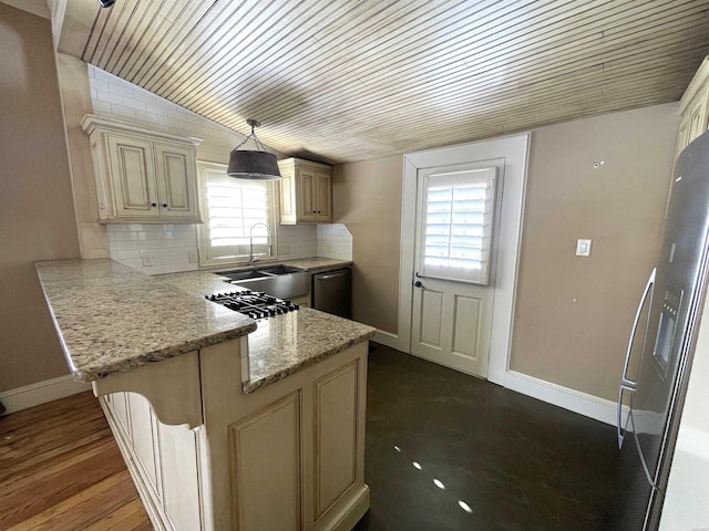 kitchen with light stone counters, cream cabinetry, decorative light fixtures, and decorative backsplash