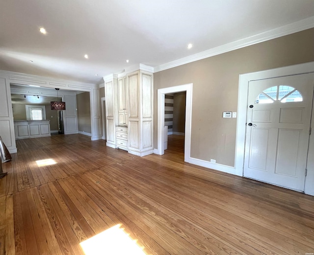 interior space featuring crown molding, baseboards, wood finished floors, and recessed lighting