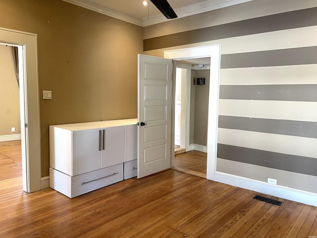 unfurnished bedroom featuring baseboards, ornamental molding, and wood finished floors