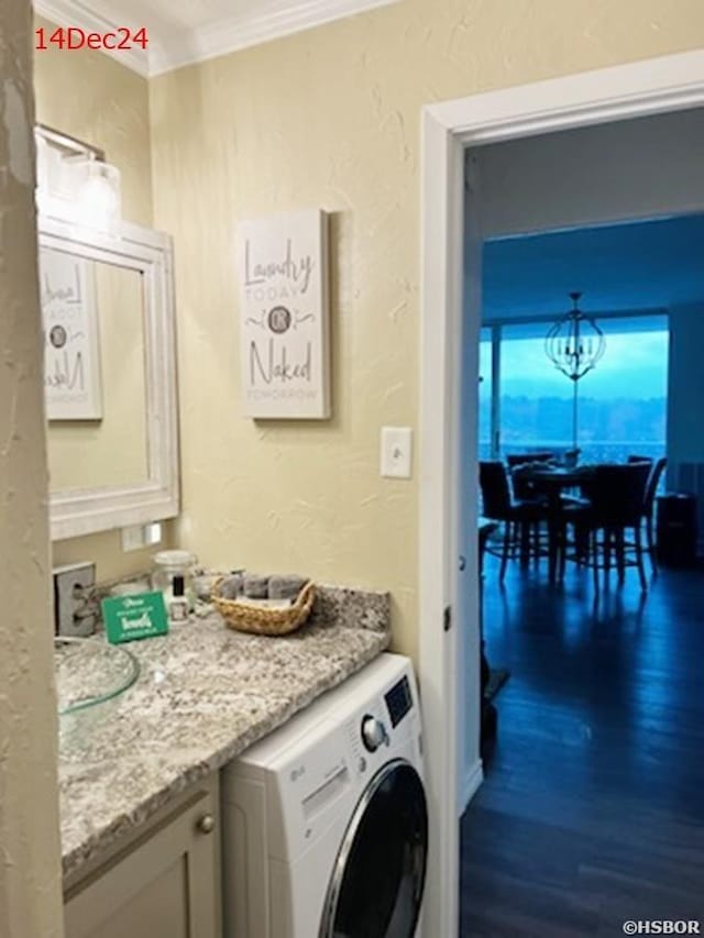 laundry area with a textured wall, washer / clothes dryer, crown molding, and laundry area