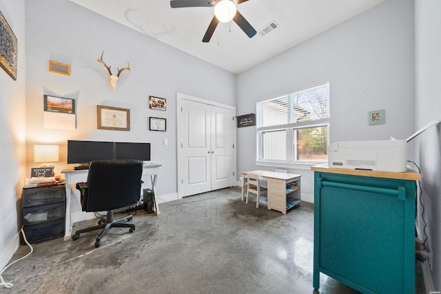 office space with a ceiling fan, concrete floors, visible vents, and baseboards