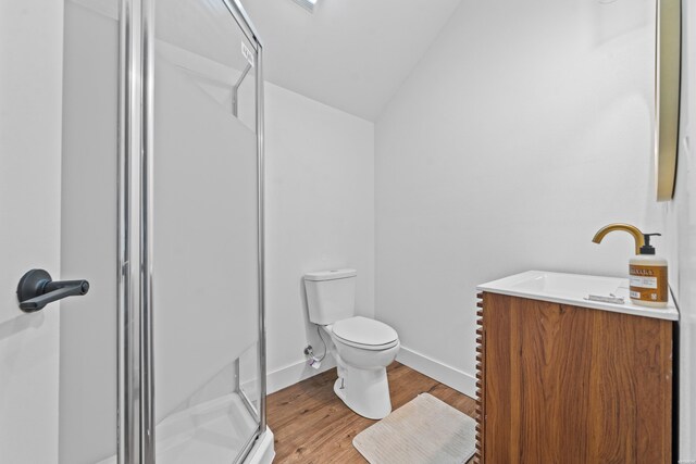 full bathroom featuring toilet, wood finished floors, baseboards, vaulted ceiling, and a shower stall