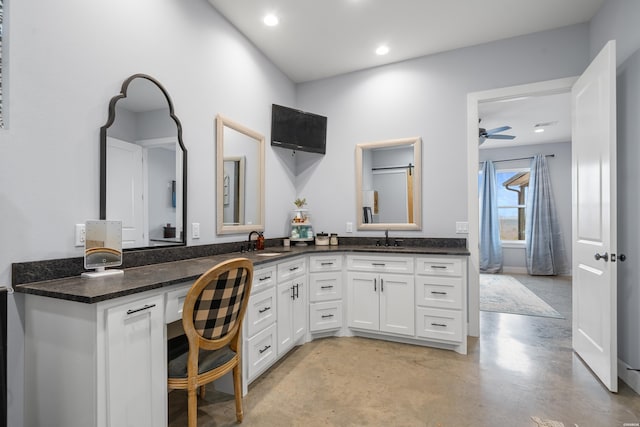 bathroom featuring finished concrete floors, recessed lighting, a sink, and double vanity