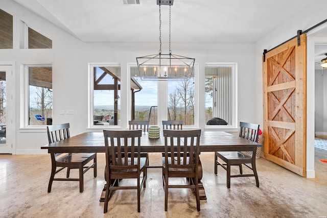 dining room featuring a barn door, baseboards, visible vents, concrete floors, and a notable chandelier