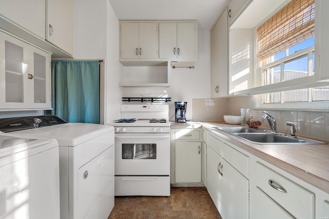 kitchen featuring glass insert cabinets, white range with gas stovetop, light countertops, and white cabinetry