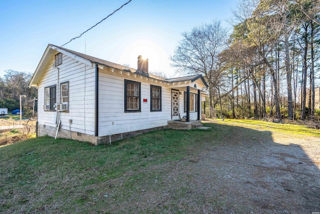 view of front of property with a chimney, a front lawn, and cooling unit