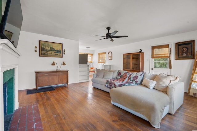 living room featuring a fireplace with flush hearth, a ceiling fan, and dark wood-style flooring