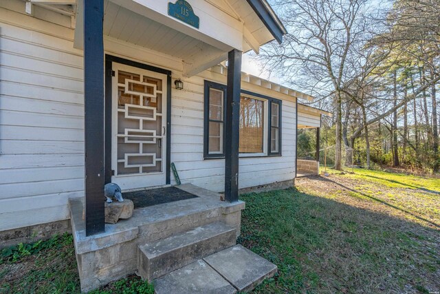 doorway to property with a lawn