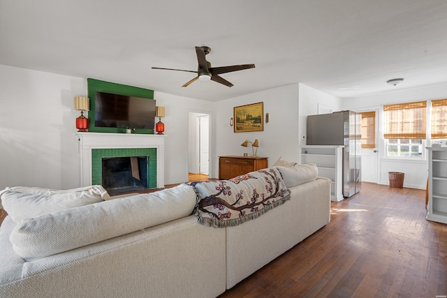 living room with dark wood-style floors, a fireplace, and ceiling fan