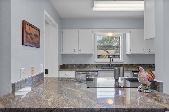 250 Grand Isle Dr Unit 5-A, Hot Springs, AR 71913 - kitchen featuring white cabinets, a peninsula, dishwasher, dark stone countertops, and a sink