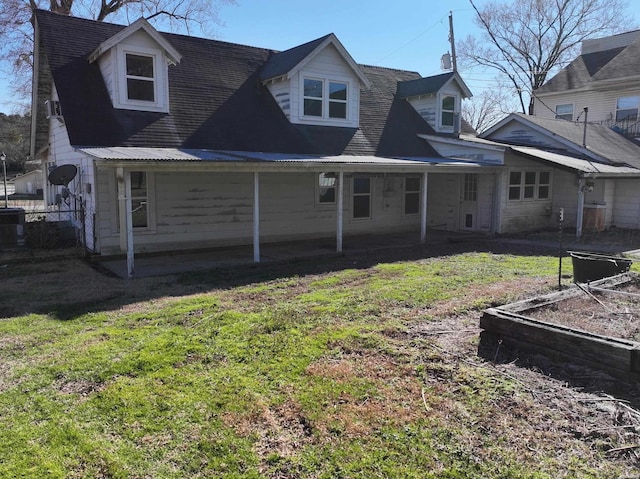 back of house with a yard, a patio area, and a garden