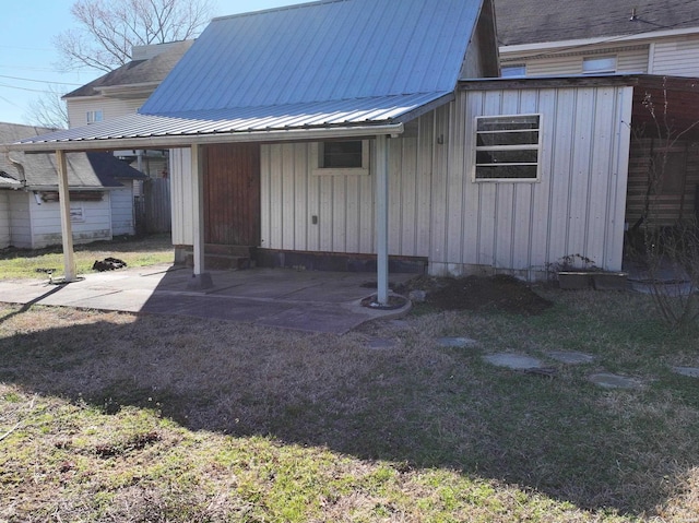 back of property with board and batten siding and metal roof