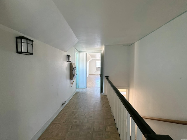 corridor featuring baseboards and an upstairs landing