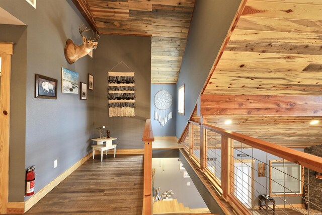 hall with lofted ceiling, dark wood finished floors, wood ceiling, and baseboards