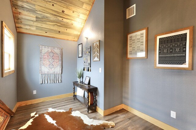 corridor with wood ceiling, visible vents, vaulted ceiling, and wood finished floors