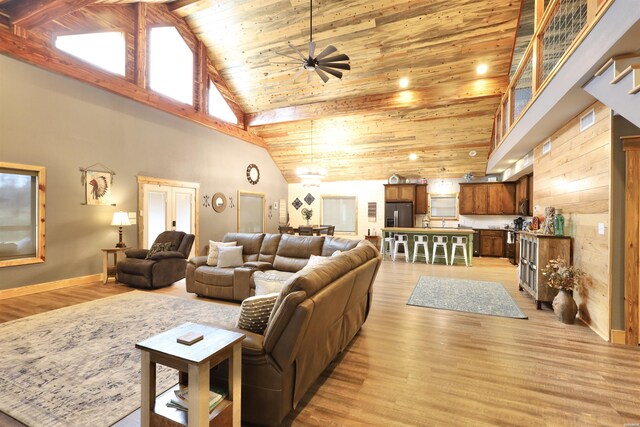 living area with high vaulted ceiling, wood ceiling, ceiling fan, and light wood finished floors