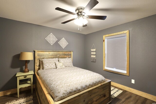 bedroom with dark wood-style flooring, ceiling fan, and baseboards