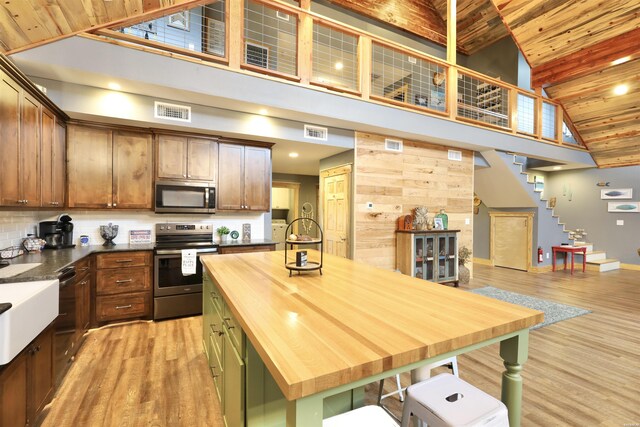 kitchen with wood ceiling, visible vents, stainless steel appliances, and light wood-style flooring