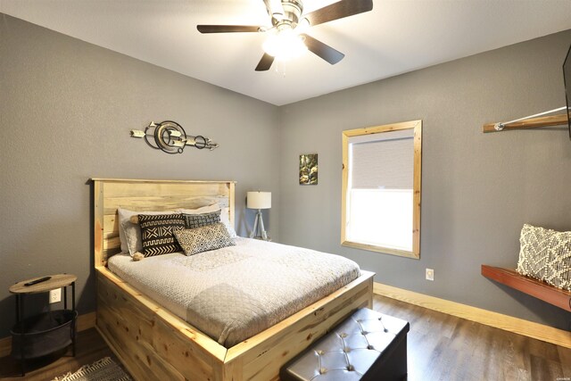 bedroom with dark wood-type flooring, baseboards, and a ceiling fan