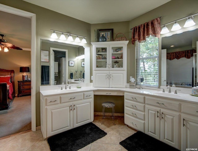 ensuite bathroom featuring two vanities, a sink, and tile patterned flooring