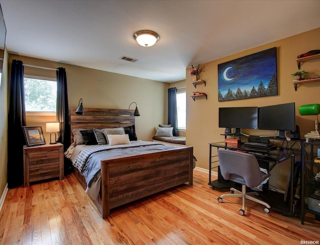 bedroom featuring light wood-type flooring, visible vents, and baseboards